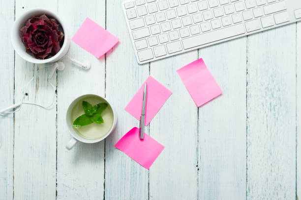 Mint tea, pink post its on office table work place with cup of mint tea, pink post its, and succulent plant, top view white shabby chic desk stock pictures, royalty-free photos & images