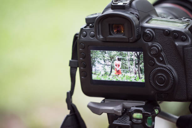 istock Asian beauty vlogger review tutorial vlog viral clip on live streaming and behind cameraman Video or professional digital mirrorless setting on tripod for camera recording at outdoor 1150049017