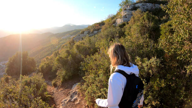 istock Female hiker walks down trail at sunset 1150051659