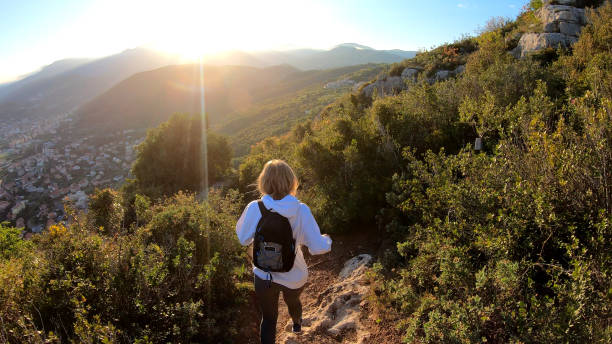 istock Female hiker walks down trail at sunset 1150051667