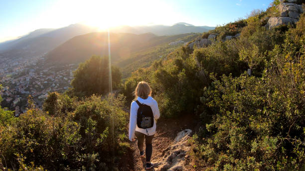 istock Female hiker walks down trail at sunset 1150051673