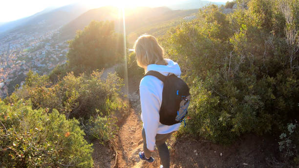 istock Female hiker walks down trail at sunset 1150051812