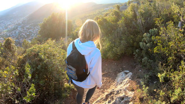 istock Female hiker walks down trail at sunset 1150051814