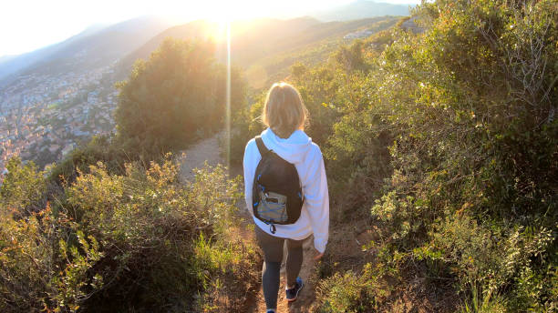istock Female hiker walks down trail at sunset 1150051822