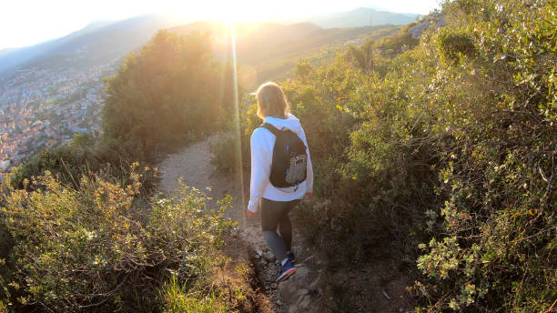 istock Female hiker walks down trail at sunset 1150051842
