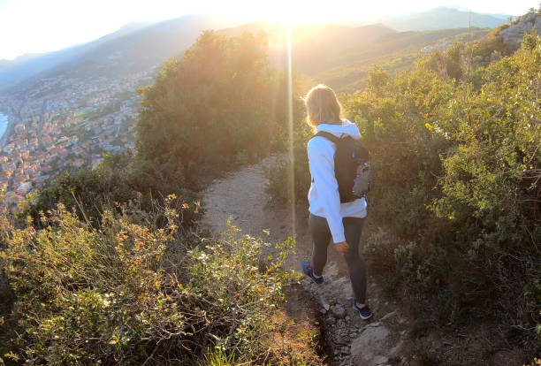 istock Female hiker walks down trail at sunset 1150051843