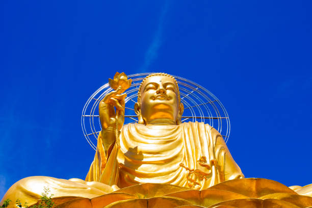 istock Huge Golden buddha statue against bright blue clear sky 1150053361