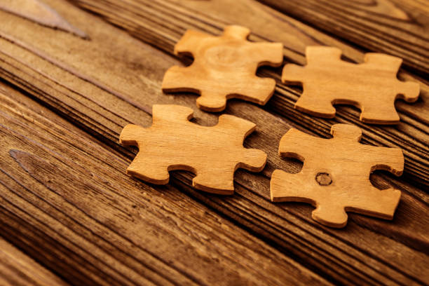 istock four wooden puzzles on a wooden background. 1150055849