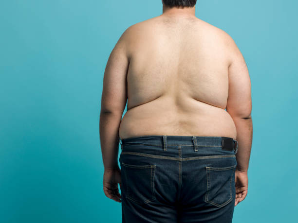 Overweight young man Overweight young man, studio shot pot belly stock pictures, royalty-free photos & images