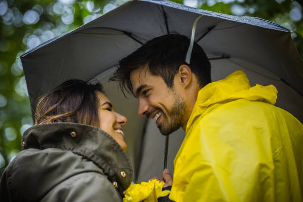 istock Couple under umbrella walking during rainy spring day 1150058358