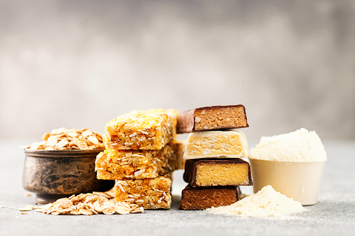 Different Energy protein bars and oatmeal bars on grey background.   Set of energy, sport, breakfast and protein bars