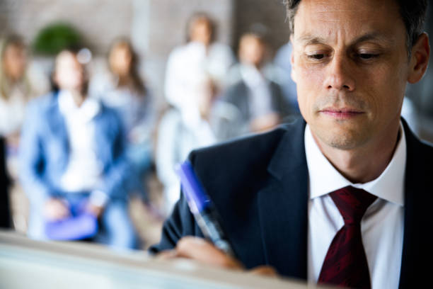 istock Male entrepreneur writing on whiteboard during a presentation in a board room. 1150058524