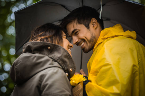 istock Couple under umbrella walking during rainy spring day 1150059516
