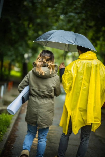 istock Couple under umbrella walking during rainy spring day 1150059904