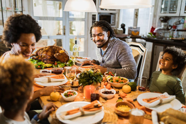 istock Happy black family communicating while having Thanksgiving meal in dining room. 1150062718
