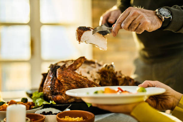 istock Unrecognizable man carving turkey meat and putting it on a plate at home. 1150063421