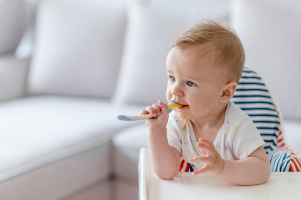 szczęśliwe dziecko jedzące siebie. - baby food zdjęcia i obrazy z banku zdjęć