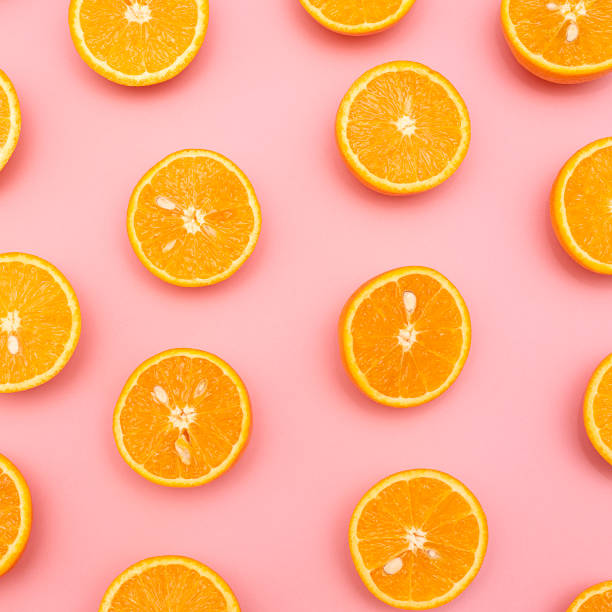 istock Orange juicy oranges split in half on pink 1150069916