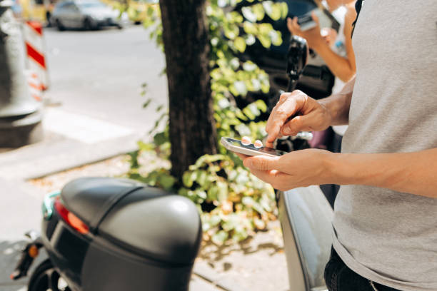 istock A guy or a tourist activates or rents an electric scooter using a mobile application on a cell phone. 1150071138