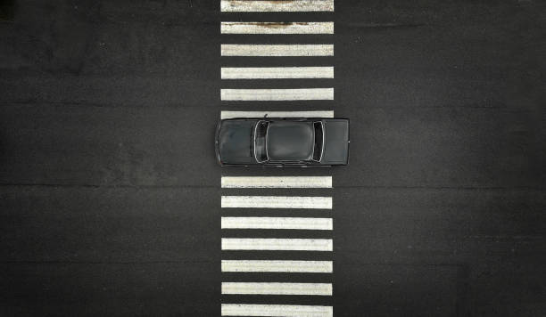 istock One black car on a zebra pedestrian crosswalk. Black asphalt on a backdrop. 1150074658