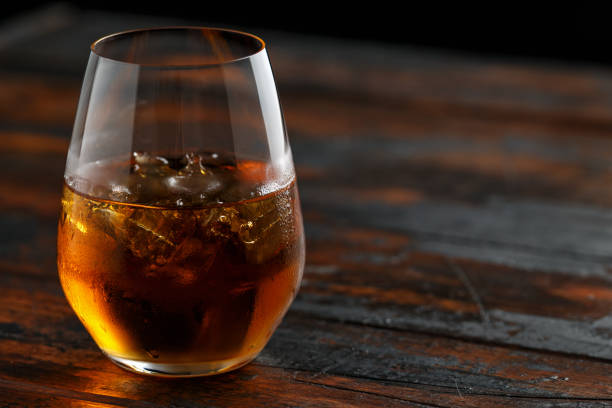 istock Glass of whiskey with ice on rustic table 1150078465