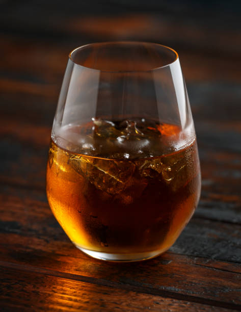 istock Glass of whiskey with ice on rustic table 1150078511