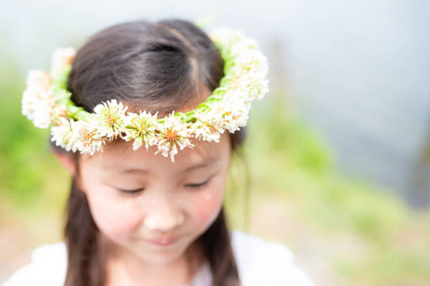 Girl wearing a crown of white clover Girl wearing a crown of white clover floral crown photos stock pictures, royalty-free photos & images