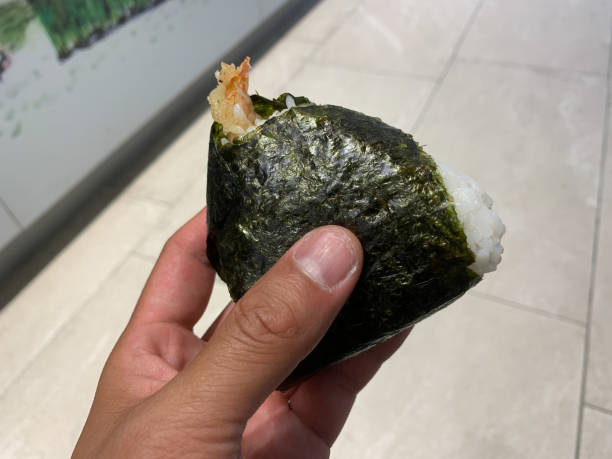 istock Hand holding a Ebi Onigiri, Shrimp Tempura Onigiri 1150080054