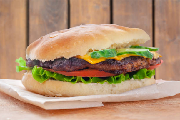 istock fresh flavored cheeseburger with juicy cutlet, cucumbers, tomato and lettuce 1150081392