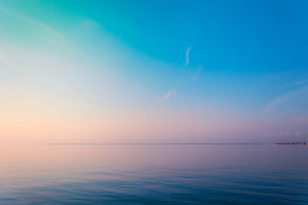 Photo of Horizontal sea line in the evening sunlight over sky background. Blue hour sunset. Summer adventure or vacation concept. Copy space.