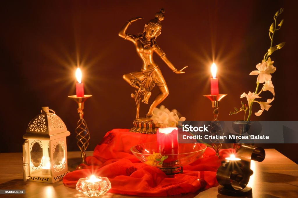 Indian statue on altar with romantic candles Traditional Indian home decor with Tara bronze statue on altar, symbol of compassion with lit candles and romantic ambiance Goddess Stock Photo
