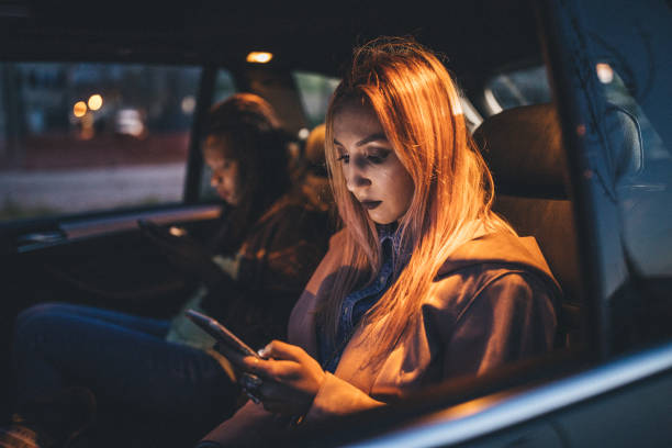 istock Friends driving in a car and text messaging 1150084119