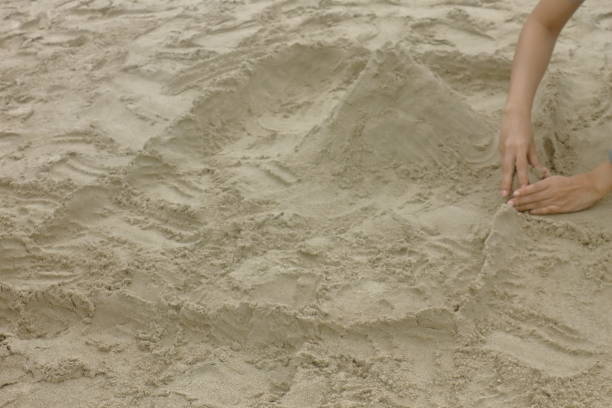 istock hand girl, playing sand on beach 1150089741