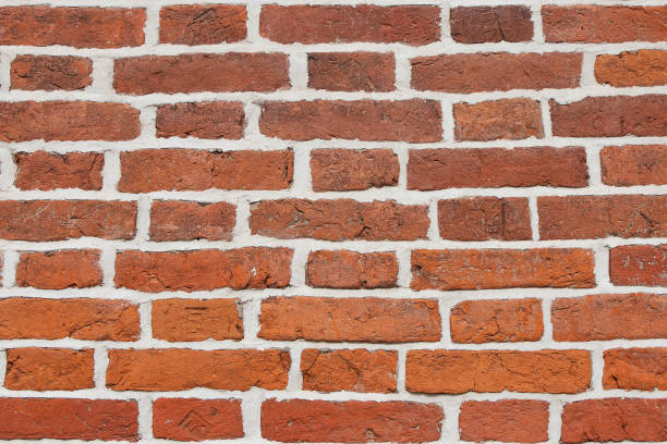 istock Texture wall of red obsolete brick. Background from old orange brickwork with white cement. 1150091088