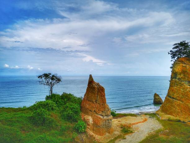 Beautiful single rock formation on the seashore with silky smooth water reflection background in Kuala Penyu Sabah. Borneo. A beautiful outdoor nature photography with a single rock formation on the seashore with silky smooth water reflection background. penyu kuala stock pictures, royalty-free photos & images