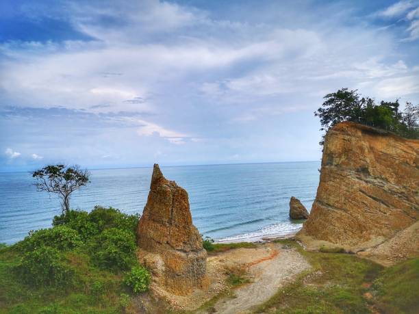 Beautiful single rock formation on the seashore with silky smooth water reflection background in Kuala Penyu Sabah. Borneo. A beautiful outdoor nature photography with a single rock formation on the seashore with silky smooth water reflection background. penyu kuala stock pictures, royalty-free photos & images
