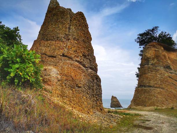 Beautiful single rock formation on the seashore with silky smooth water reflection background in Kuala Penyu Sabah. Borneo. A beautiful outdoor nature photography with a single rock formation on the seashore with silky smooth water reflection background. penyu kuala stock pictures, royalty-free photos & images