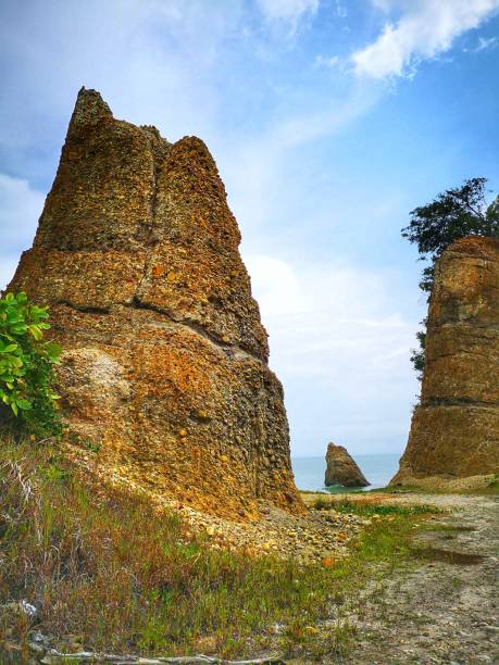 Beautiful single rock formation on the seashore with silky smooth water reflection background in Kuala Penyu Sabah. Borneo. A beautiful outdoor nature photography with a single rock formation on the seashore with silky smooth water reflection background. penyu kuala stock pictures, royalty-free photos & images