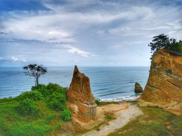 Beautiful single rock formation on the seashore with silky smooth water reflection background in Kuala Penyu Sabah. Borneo. A beautiful outdoor nature photography with a single rock formation on the seashore with silky smooth water reflection background. penyu kuala stock pictures, royalty-free photos & images