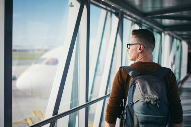 homem na ponte de embarque do passageiro - airplane window indoors looking through window - fotografias e filmes do acervo