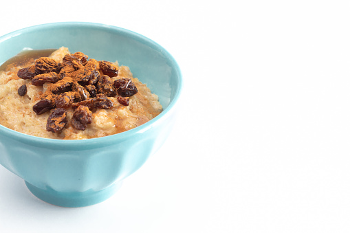 Cinnamon Raisin Oatmeal in a Blue Bowl Isolated on a White Background
