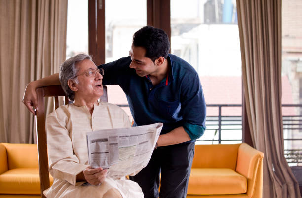 man with senior father at home - reading newspaper 30s adult imagens e fotografias de stock