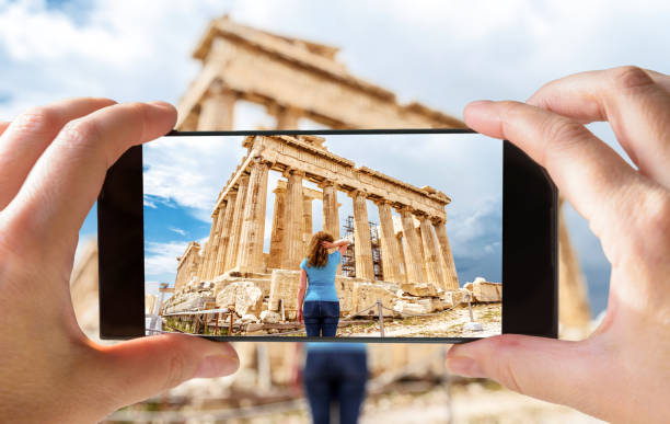 Tourist taking photo of young woman in Athens by cell phone, Greece Tourist taking photo of young woman in Athens by cell phone, Greece. This place is a top landmark of Athens. Picture of the Ancient Greek Parthenon on smartphone. Traveling and vacation concept. athens greece photos stock pictures, royalty-free photos & images