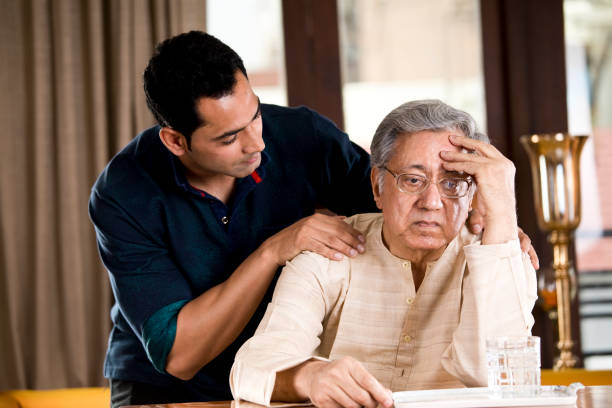 hijo consolando a su padre en casa - son in law fotografías e imágenes de stock