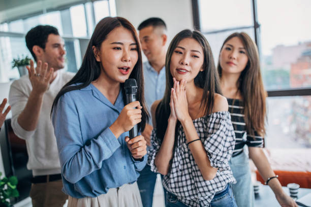 istock Group of friends playing karaoke at home 1150121086