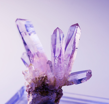 Druze of several purple crystals of natural gemstone amethyst from Vera Cruz mine on violet background