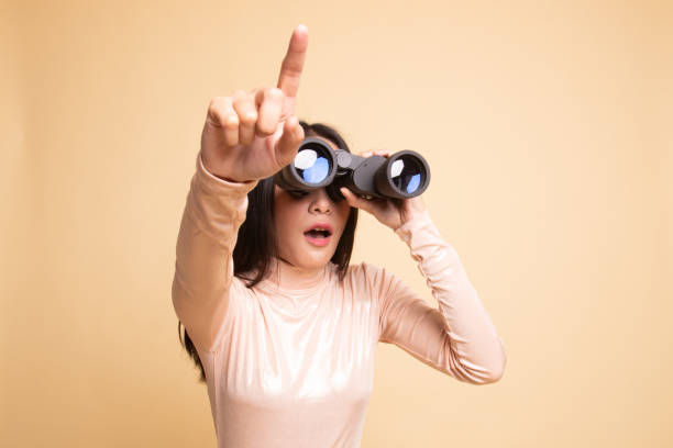 istock Young Asian woman  point and look with binoculars. 1150122053