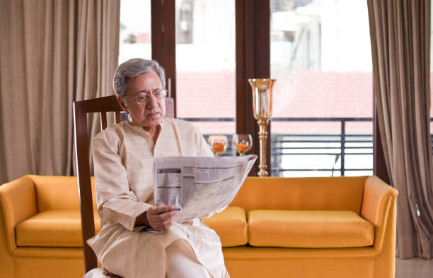 istock Senior man reading newspaper at home 1150122110