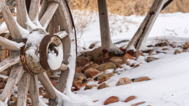 istock Panorama An old wooden wagon with rusty wheels dusted with snow in winter 1150122621