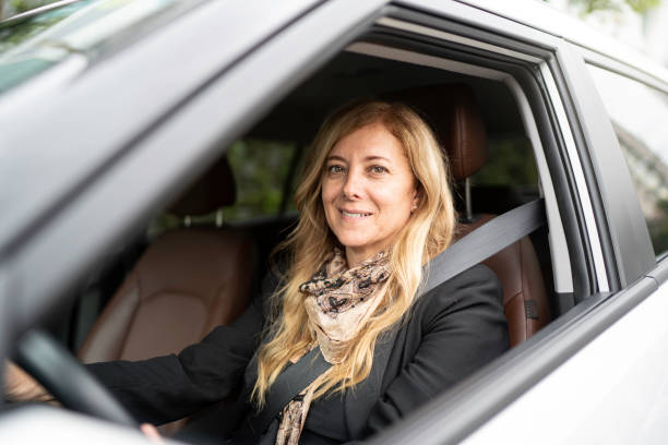 istock Portrait of a female driver smiling inside a car 1150129068